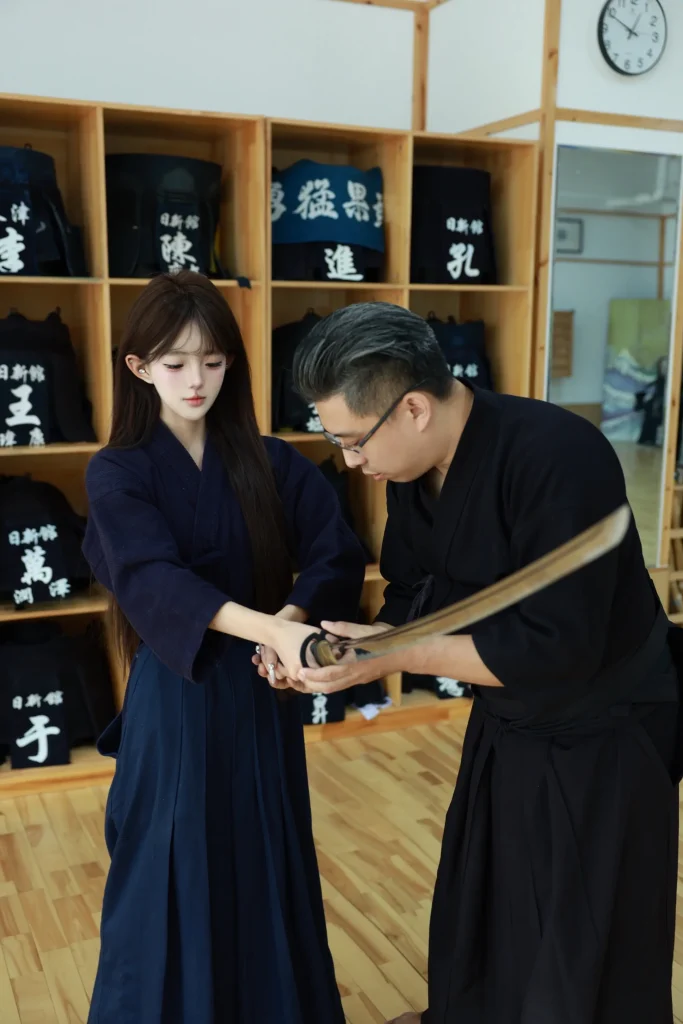 道场真实指导场景，老师向来访者示范握持竹刀的动作